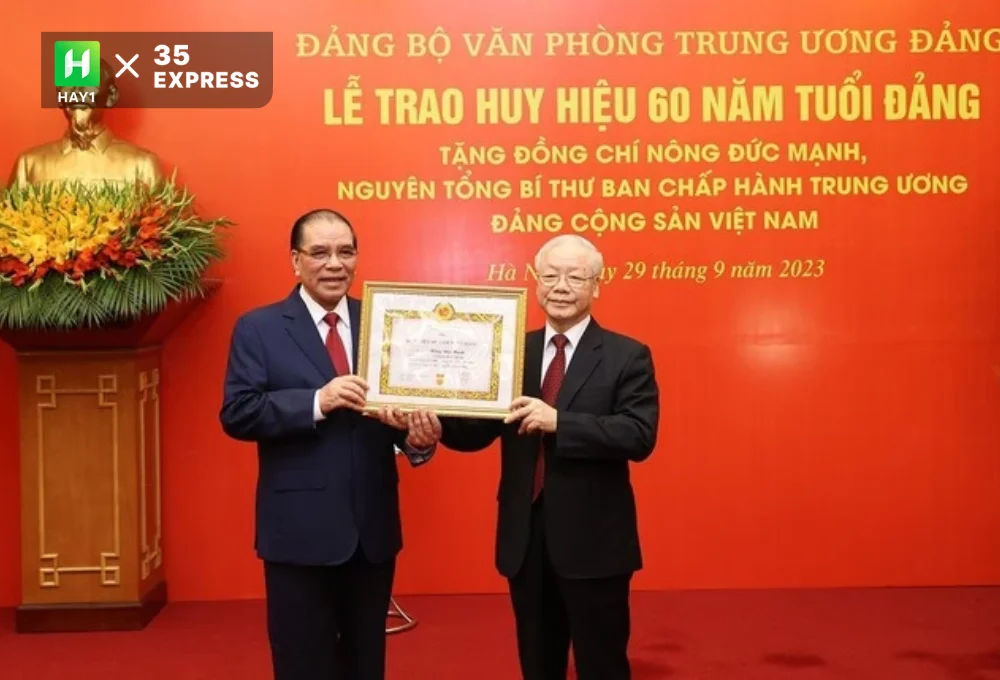 Nguyên Tổng Bí thư Nông Đức Mạnh (trái) nhận Huy hiệu 60 năm tuổi Đảng