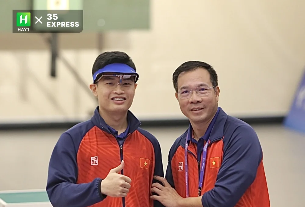 Phạm Quang Huy bên cạnh HLV Hoàng Xuân Vinh (phải)